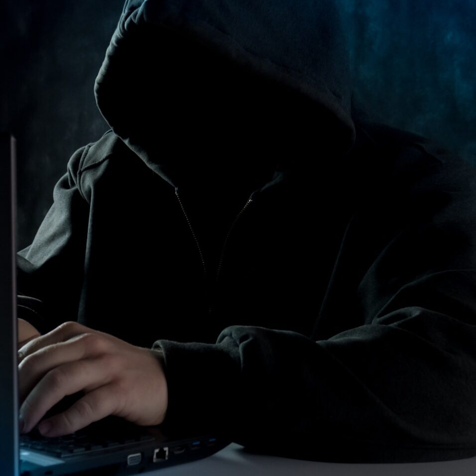 a man in a hoodie using a laptop computer