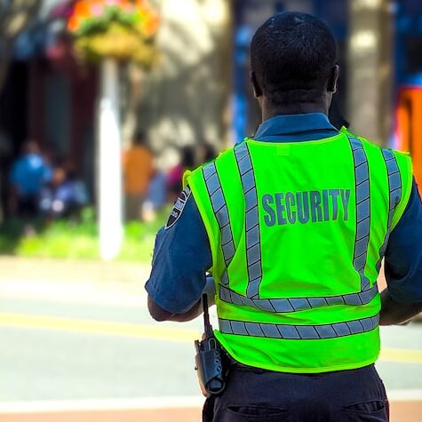 man in green and blue jacket walking on street during daytime